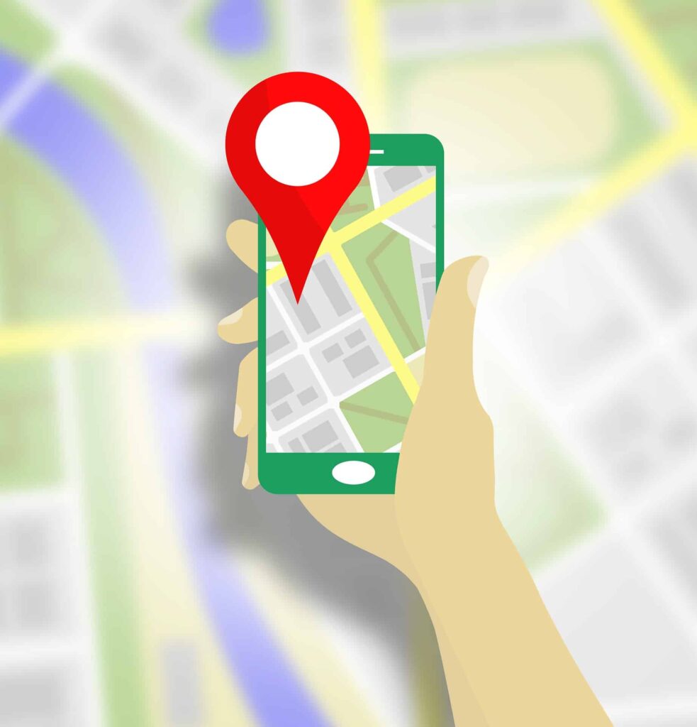 Illustrated hand holding a smartphone with a map pin on a street map, representing local SEO