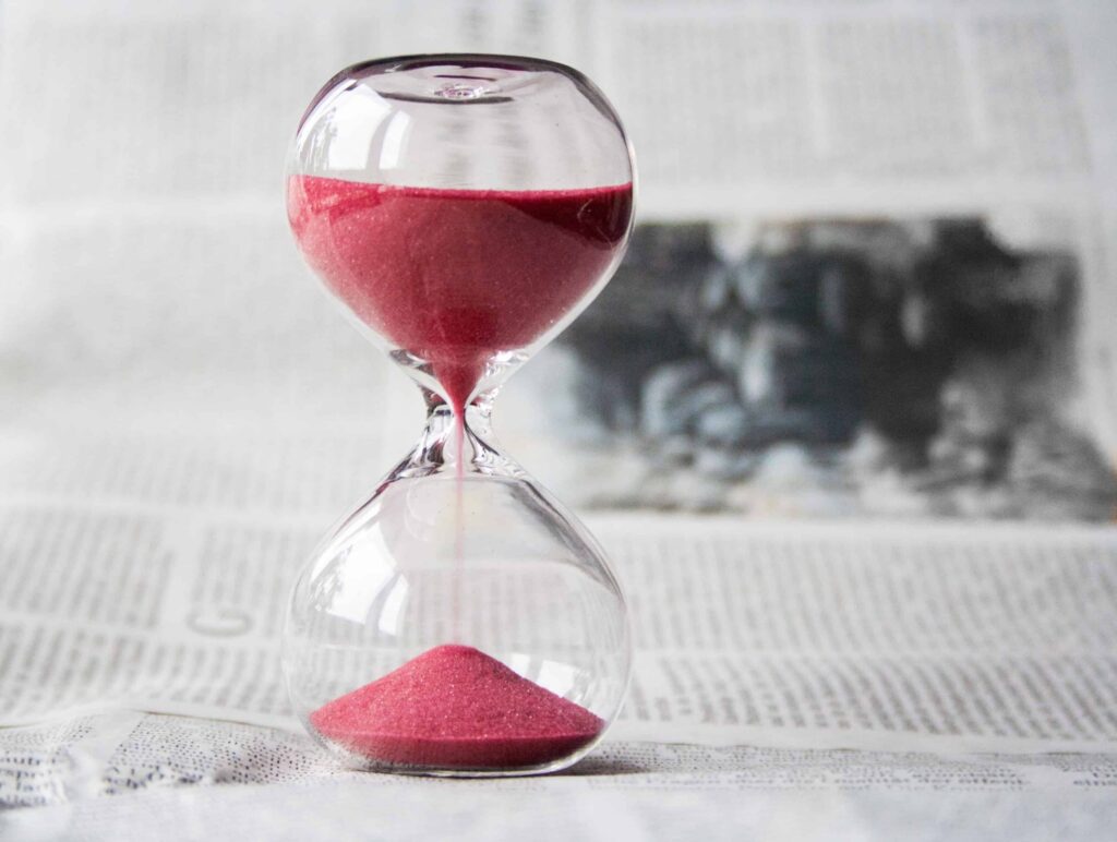 an hourglass with red sand flowing