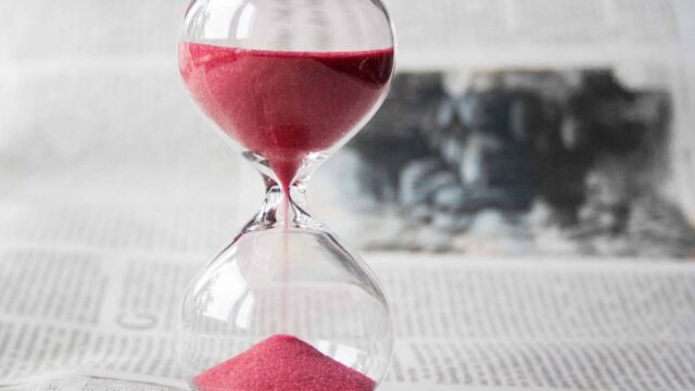 an hourglass with red sand flowing
