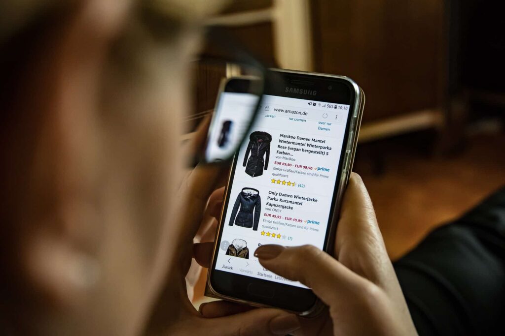 Person browsing Amazon product listings on a Samsung smartphone, illustrating how to rank in Amazon search results