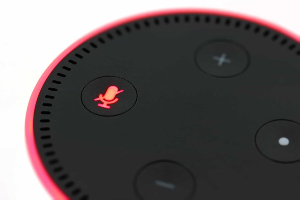 Close-up of an Amazon Echo Dot smart speaker with the muted microphone button glowing red