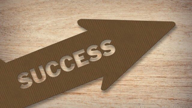 Arrow-shaped sign with the word Success carved into wood, symbolising digital marketing results