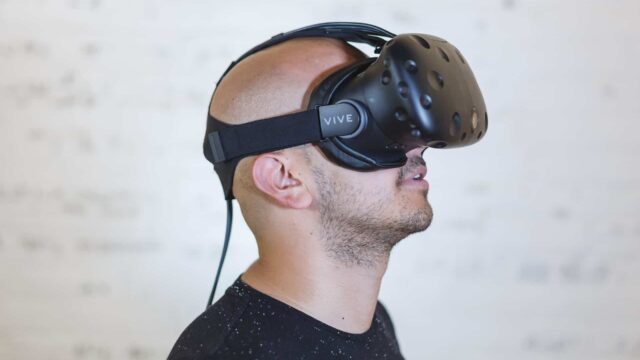 Man wearing HTC Vive virtual reality headset looking upward