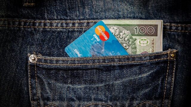 Credit card and 100-dollar banknote in a denim jeans pocket, representing affordable SEO budget