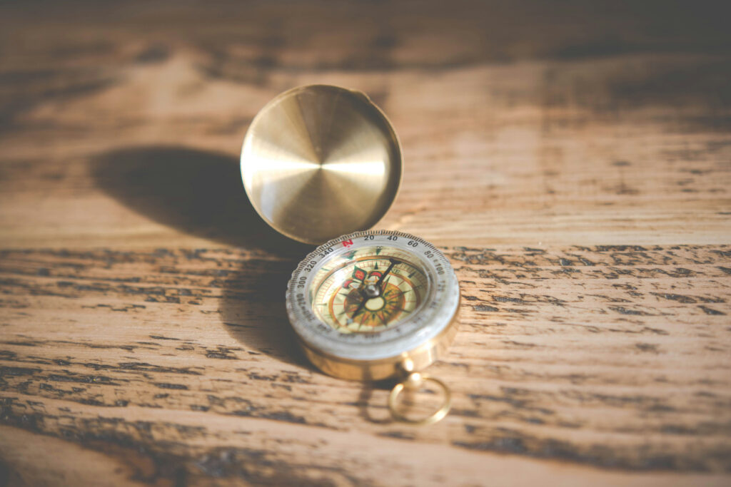 Brass compass resting on a wooden table
