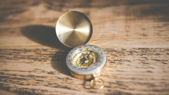 Brass compass resting on a wooden table
