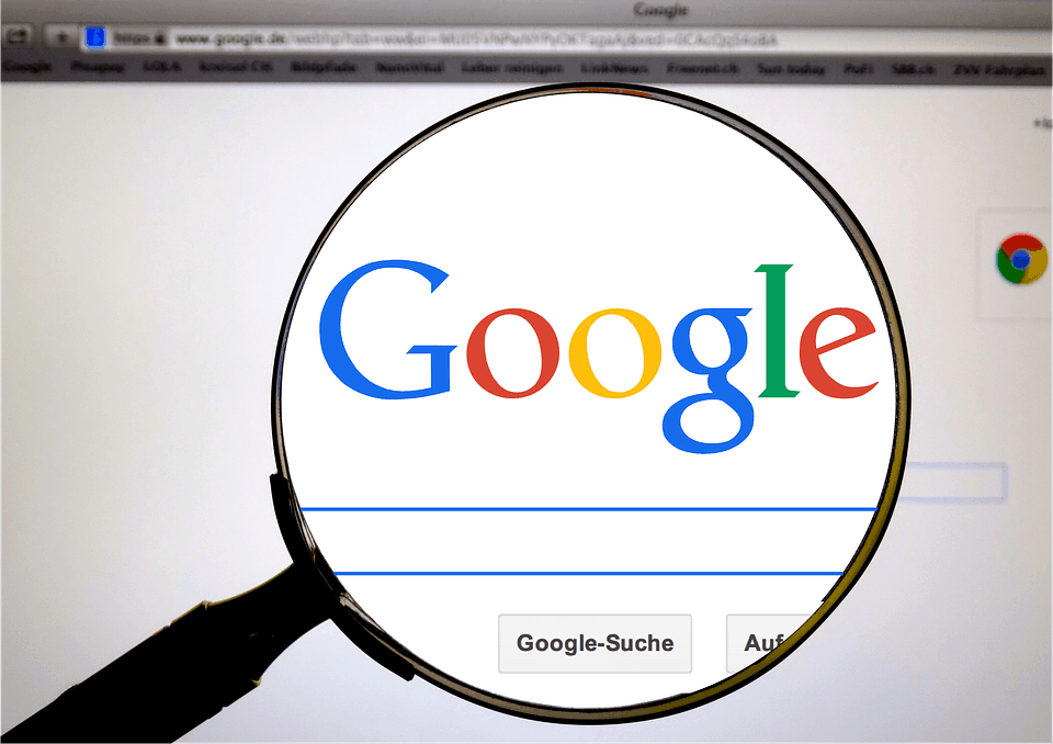 Magnifying glass over the Google homepage, illustrating scrutiny of Google's influence on elections and search