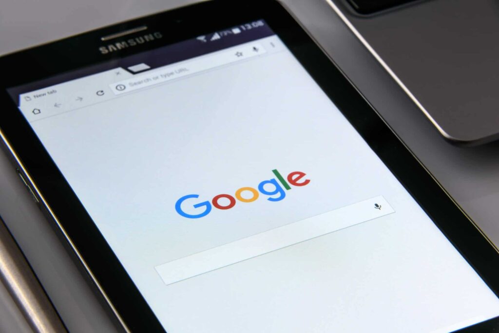 Samsung Android tablet lying on a desk with Google search homepage displayed on screen