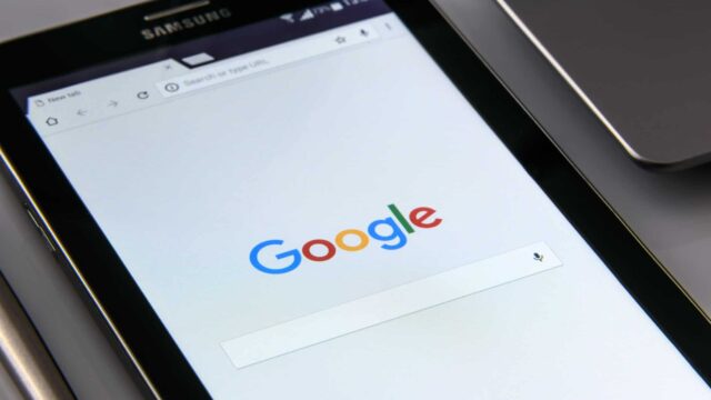 Samsung Android tablet lying on a desk with Google search homepage displayed on screen