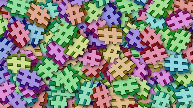 Pile of colourful 3D hashtag symbols in pastel shades illustrating branded hashtag strategy on social media