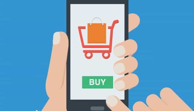 Hand holding a smartphone with a shopping cart icon and Buy button on screen, representing mobile ecommerce checkout