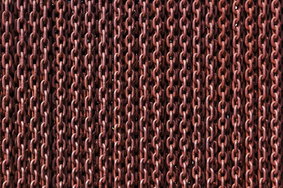 Close-up of rows of rust-coloured metal chain links, representing backlinks in SEO