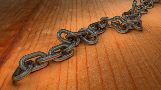 Metal chain lying on a wooden surface, representing link building and backlinks in SEO