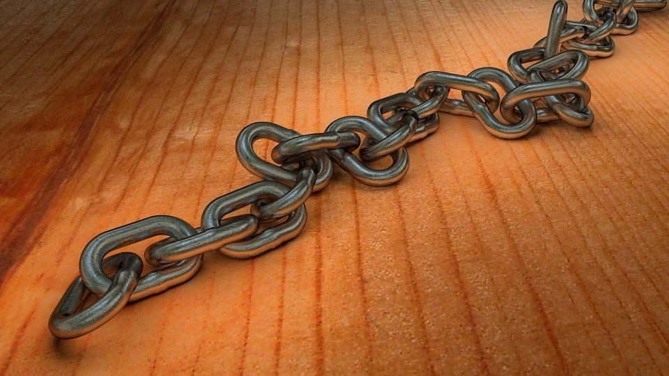 Metal chain lying on a wooden surface, representing link building and backlinks in SEO