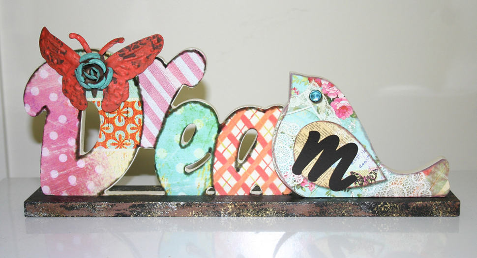 Colourful decorative wooden letters spelling DREAM on a display stand, representing the DREAM outreach model