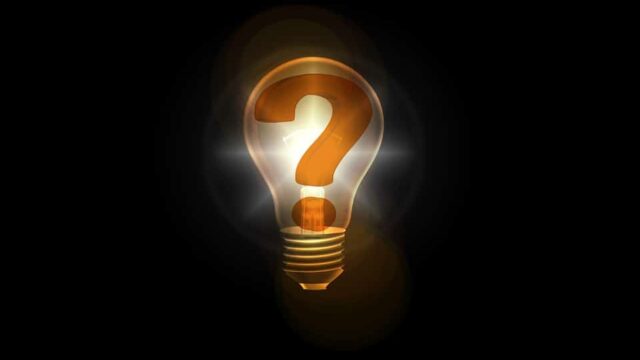 Glowing light bulb containing a question mark against a dark background, representing SEO questions