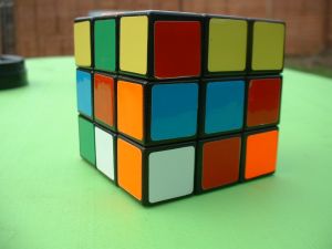 Colourful unsolved Rubik's cube on a green surface, used to illustrate problem-solving and internet history