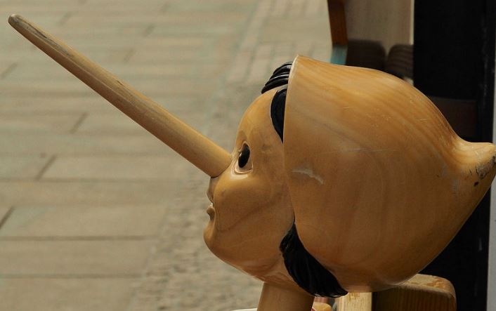 Wooden Pinocchio puppet with an elongated nose, symbolising false promises made by dishonest SEO agencies
