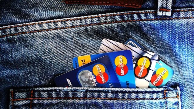 Multiple Mastercard credit cards sticking out of a denim jeans back pocket