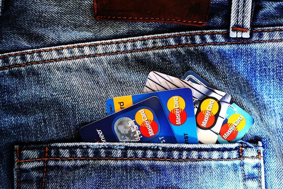 Multiple Mastercard credit cards sticking out of a denim jeans back pocket