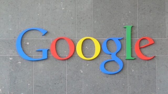 Google logo mounted in large colourful letters on a grey tile wall