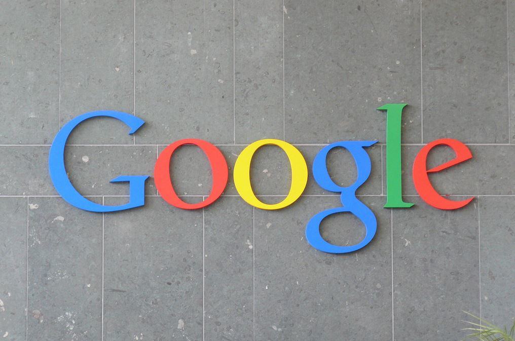 Google logo mounted in large colourful letters on a grey tile wall