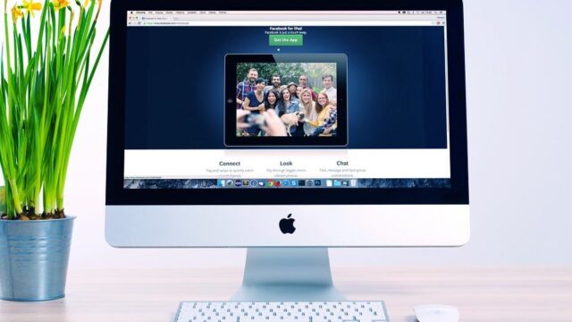 iMac on a desk displaying a website with a group photo, representing website speed and performance