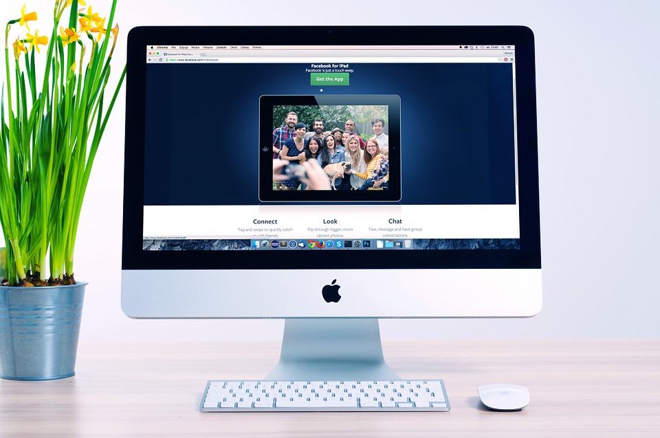 iMac on a desk displaying a website with a group photo, representing website speed and performance