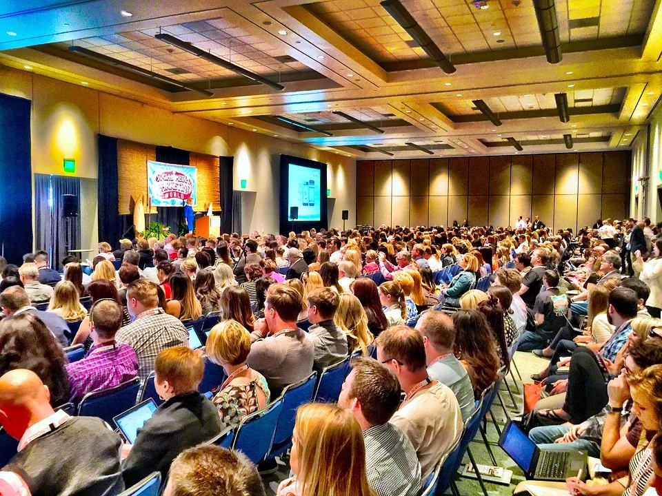Packed conference hall at WordCamp with hundreds of attendees watching a presentation on stage