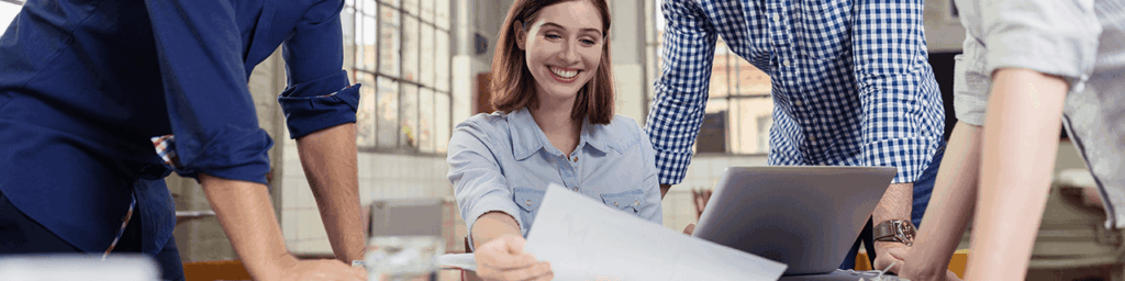 Smiling woman reviewing documents with colleagues, illustrating a WordCamp presentation about working without difficult clients